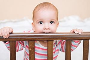 Baby Boy Chewing on Crib